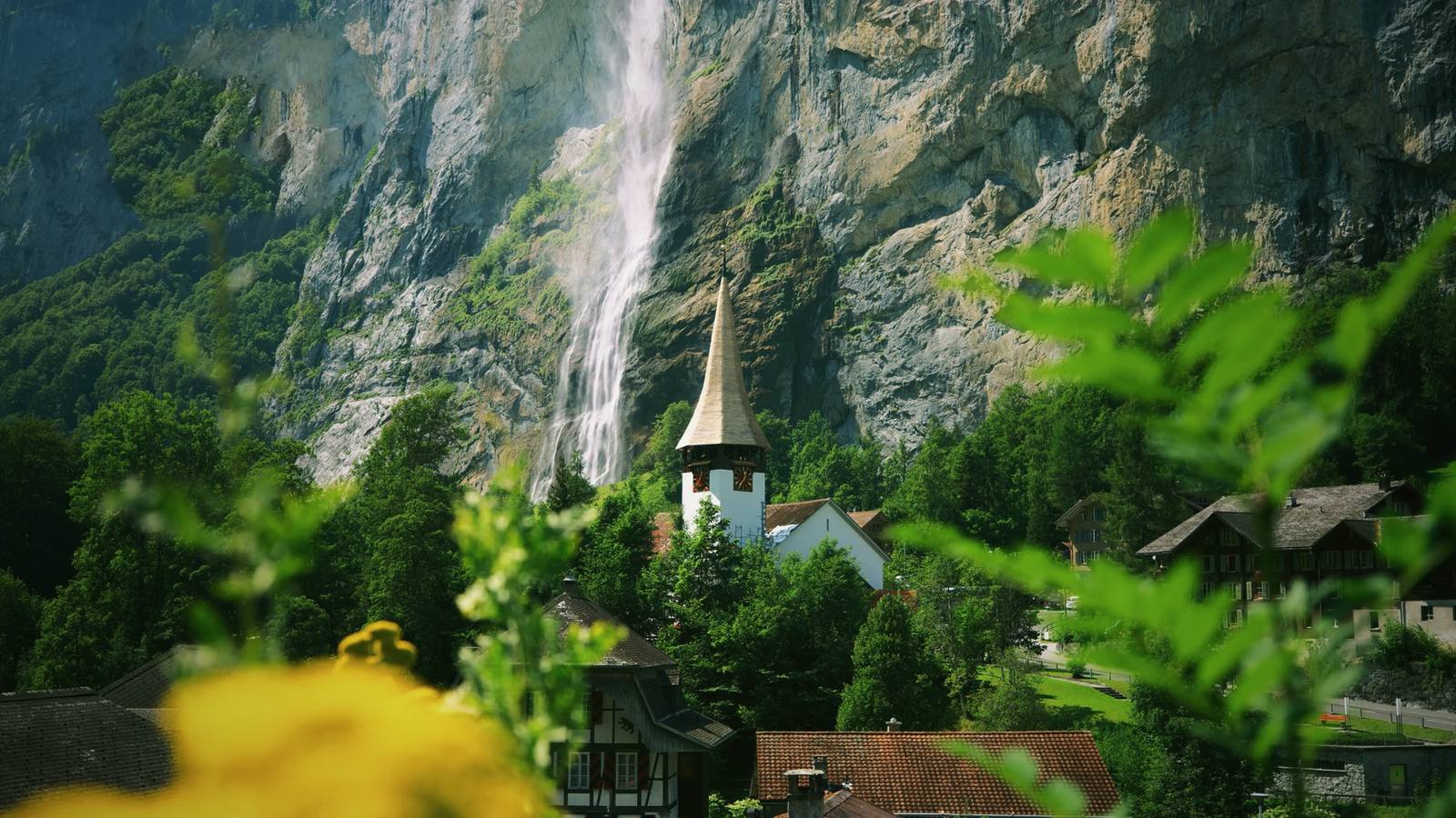 The Swiss village of Lauterbrunnen, its church spire below the Staubbach waterfall.