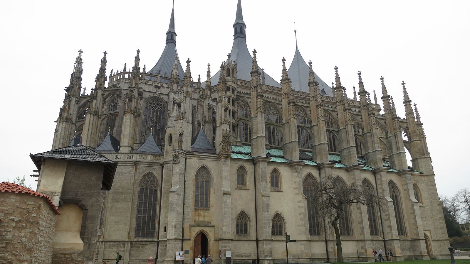 The north side of St Barbara's Church in Kutná Hora, showing its flying buttresses, tall Gothic windows and three tent shaped roofs.