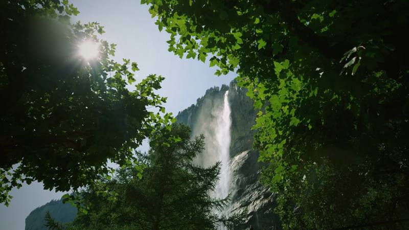 The Staubbach waterfall in Lauterbrunnen, seen through summer trees.